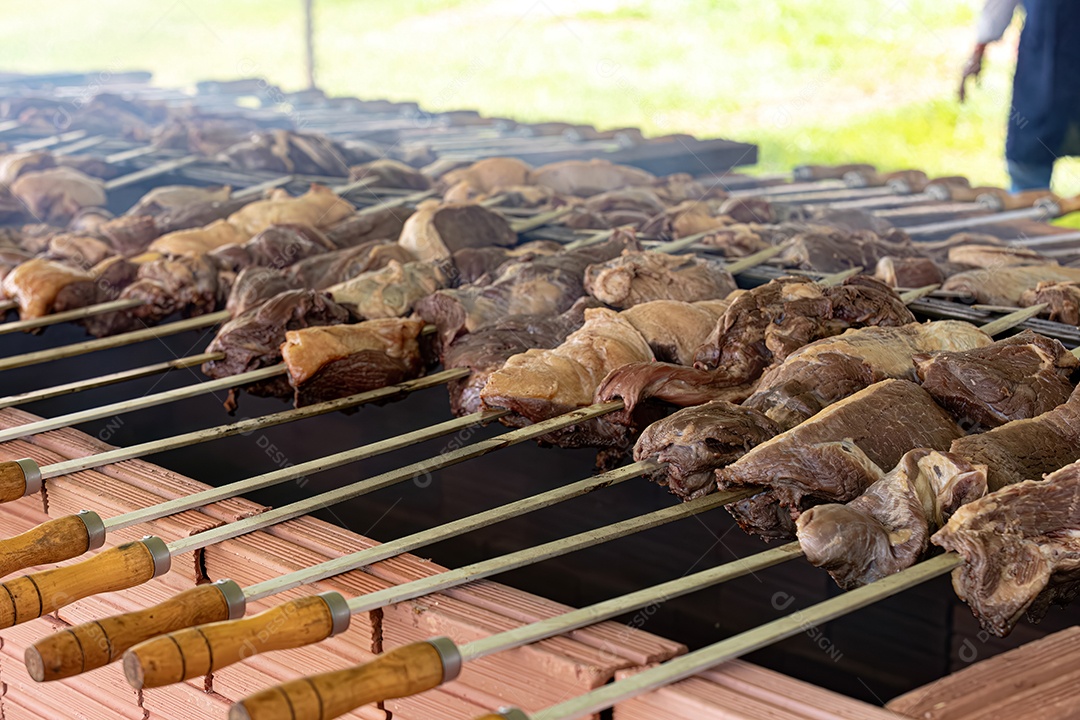 Espetos de carne assando em churrasqueira