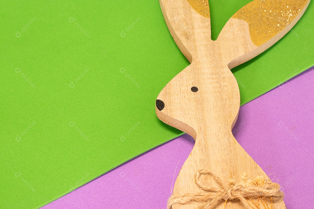 Coelho de madeira pintado artesanal sobre fundo colorido