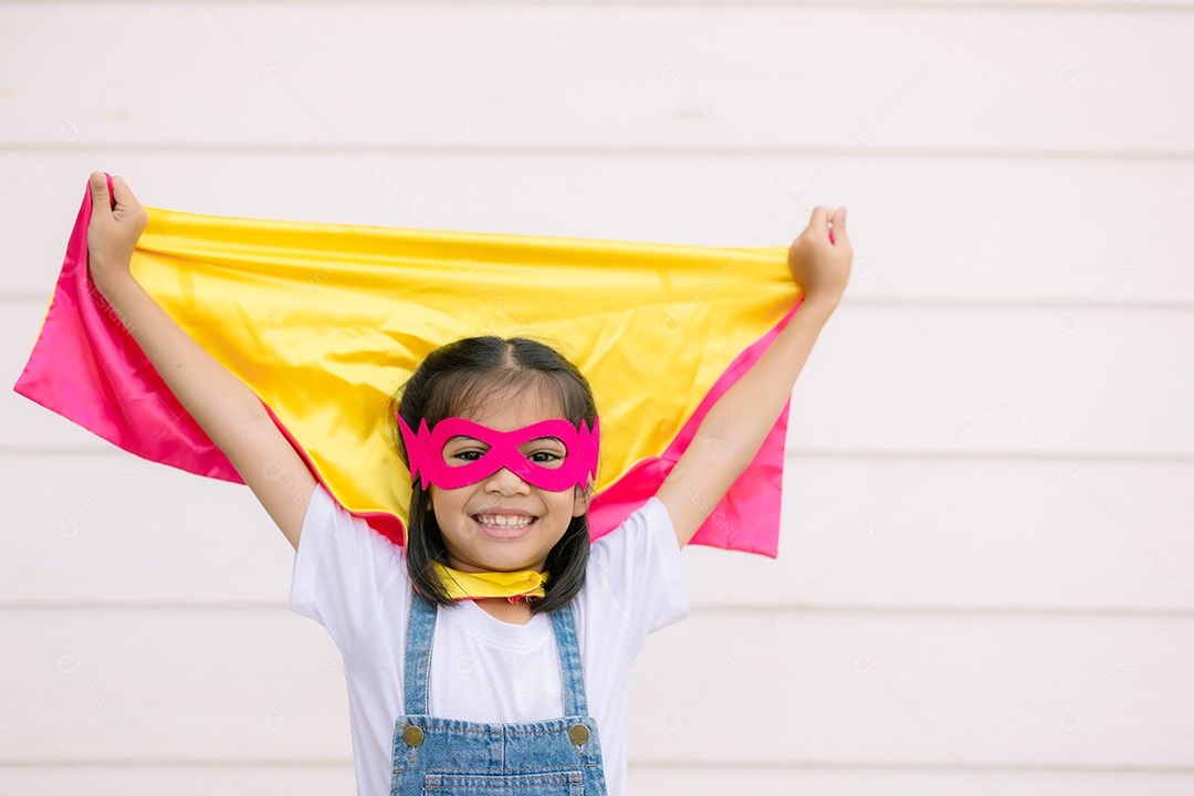 Uma garotinha engraçada vestindo uma fantasia de super herói