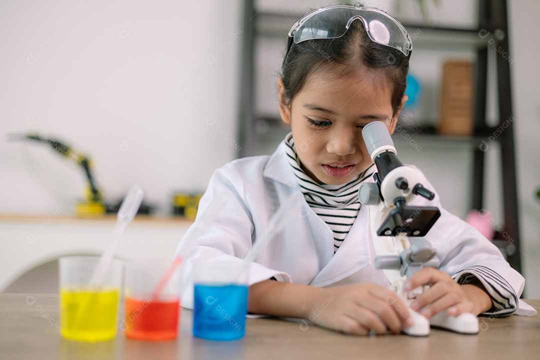 Garotinha fazendo estudo de células no microscópio