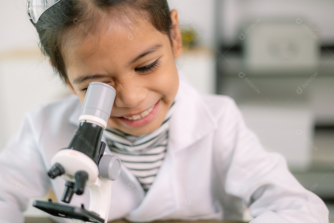 Garotinha fazendo estudo de células no microscópio