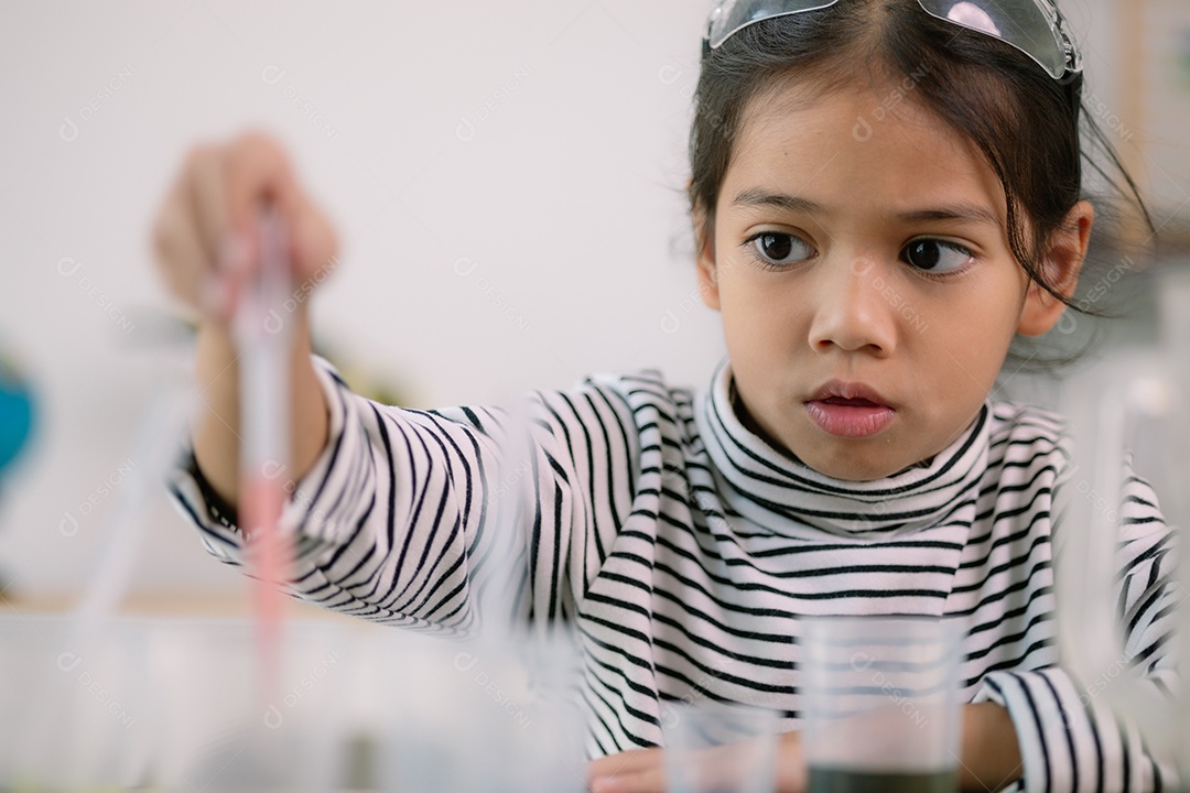 Uma criança linda concentrada fazendo experencia cientifica