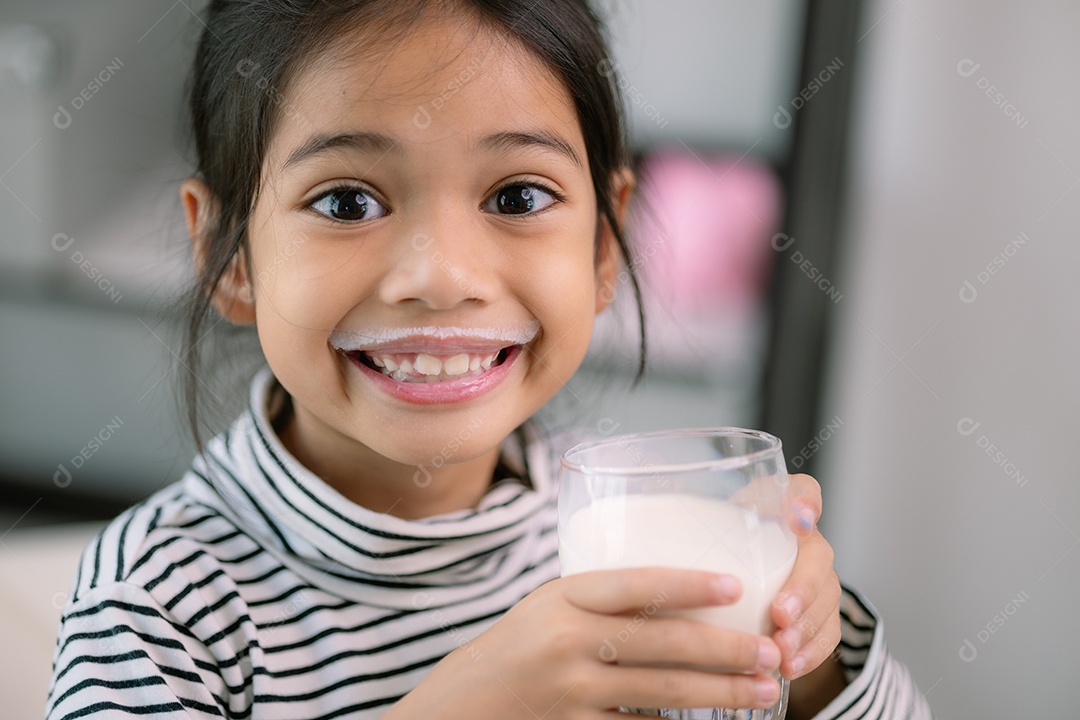 Linda menina asiática sorridente com copo de leite