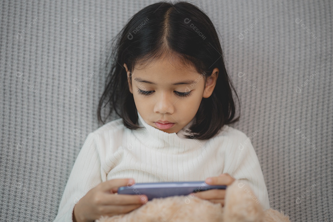 Menina  concentrada mexendo no celular