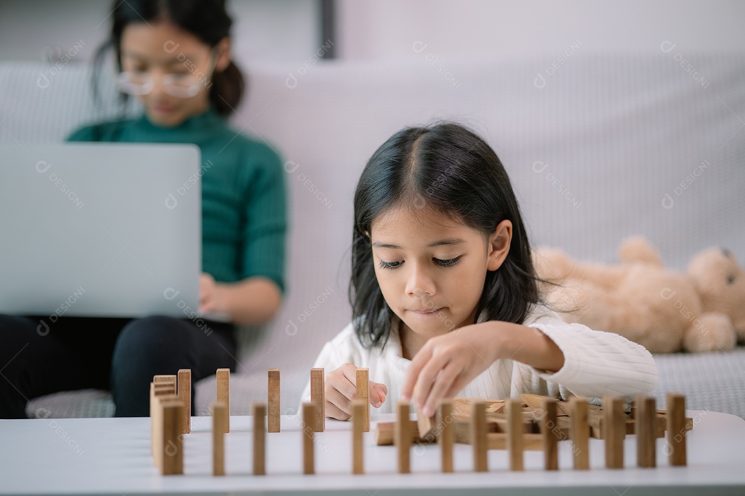 Uma menina linda está brincando com blocos de madeira sobre uma mesa