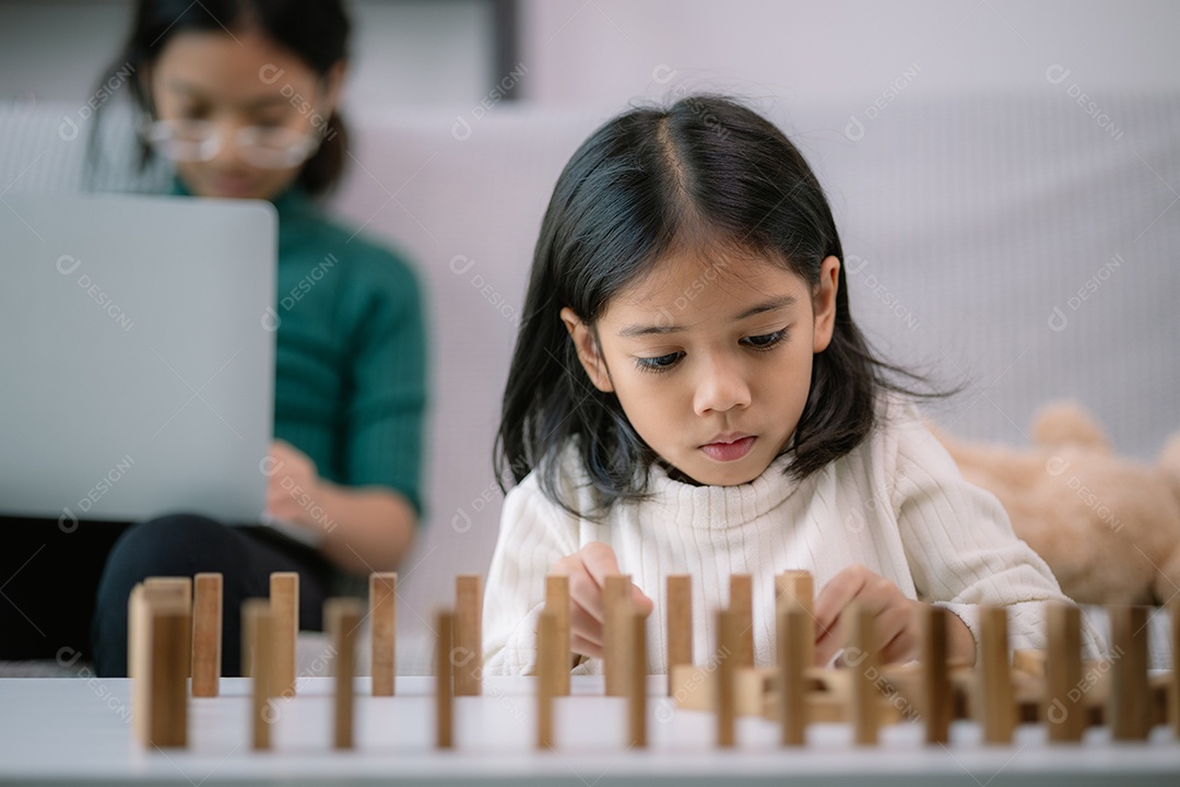Uma menina linda está brincando com blocos de madeira sobre uma mesa