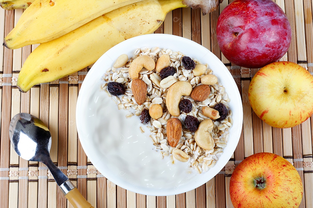 Iogurte natural com granola caseira morangos e nozes em tigela de cerâmica