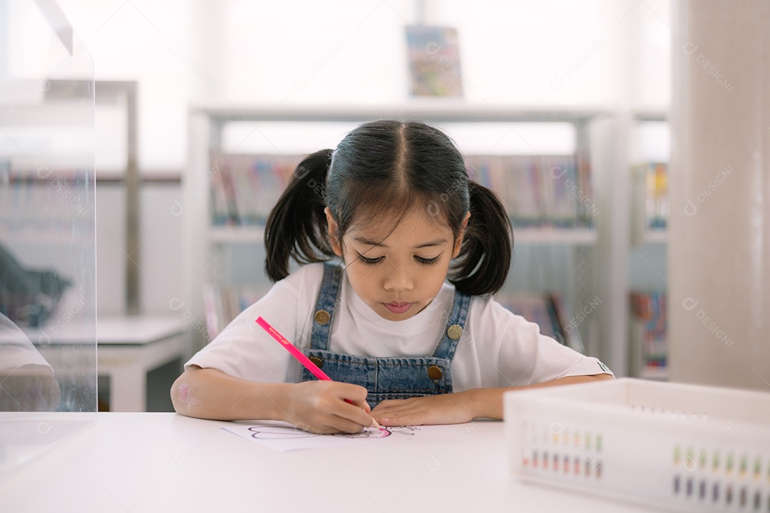 Criança fofa estudando na biblioteca