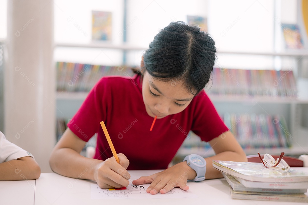 Garota linda fazendo seu dever de casa na biblioteca