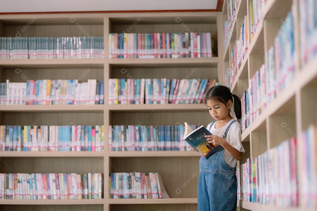 Menina lendo um livro na biblioteca