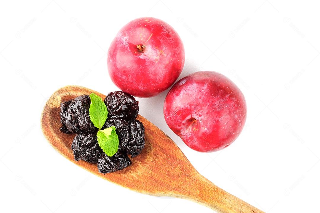 Colher de madeira com ameixas secas sobre uma colher de madeira