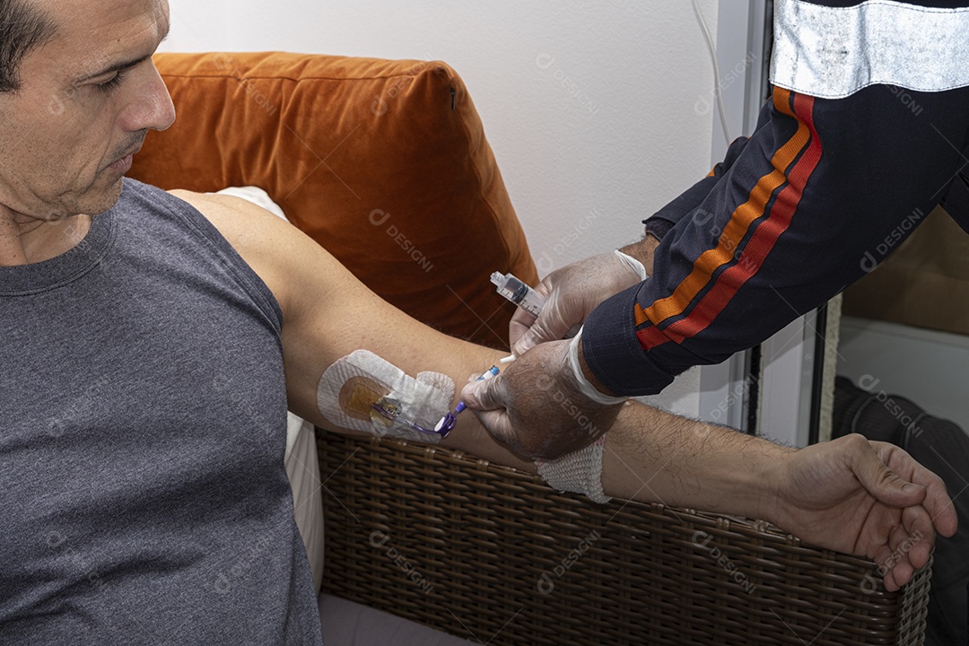 Enfermeiro aplicando remédio no cateter do paciente