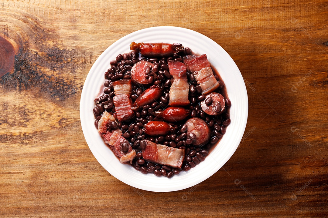 Um prato cheio de feijoada sobre fundo de mesa