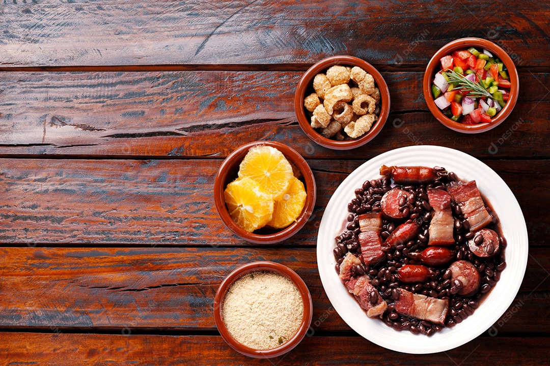 Feijoada brasileira com acompanhamento arroz laranja torresmo salada