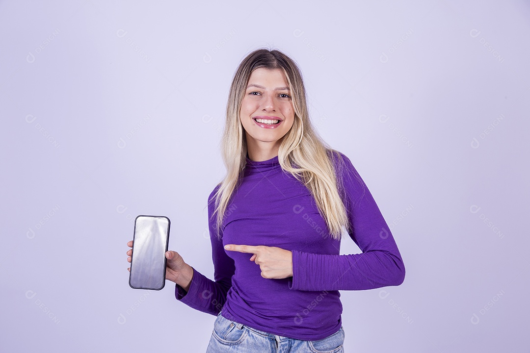 Linda mulher jovem sobre fundo isolado segurando celular smartphone