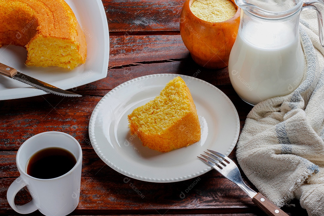 Bolo de milho com coco na chapa branca sobre mesa de madeira rústica