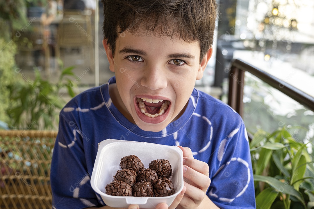 Criança feliz com bandeja de brigadeiro