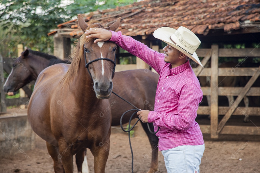 Homem jovem fazendeiro cuidando de seu cavalo