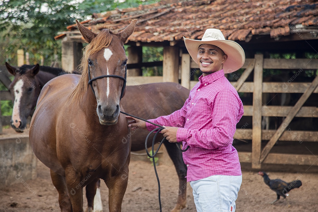 Homem jovem fazendeiro cuidando de seu caval