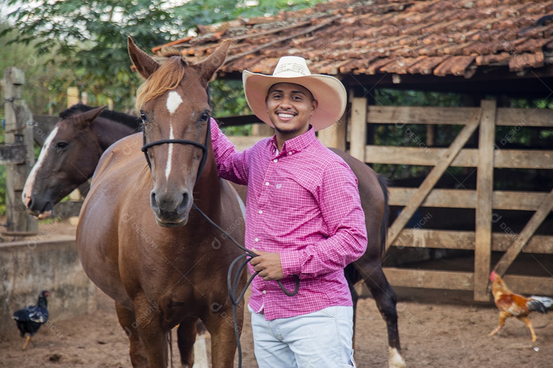 Homem jovem fazendeiro cuidando de seu cavalo