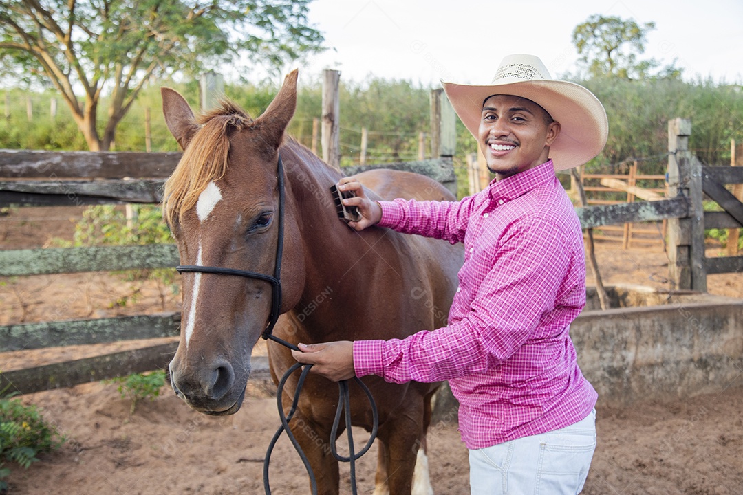 Homem jovem fazendeiro cuidando de seus cavalos