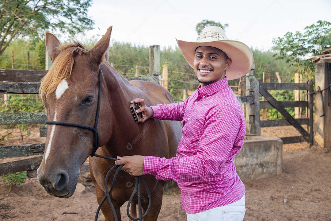 Homem jovem fazendeiro cuidando de seus cavalos