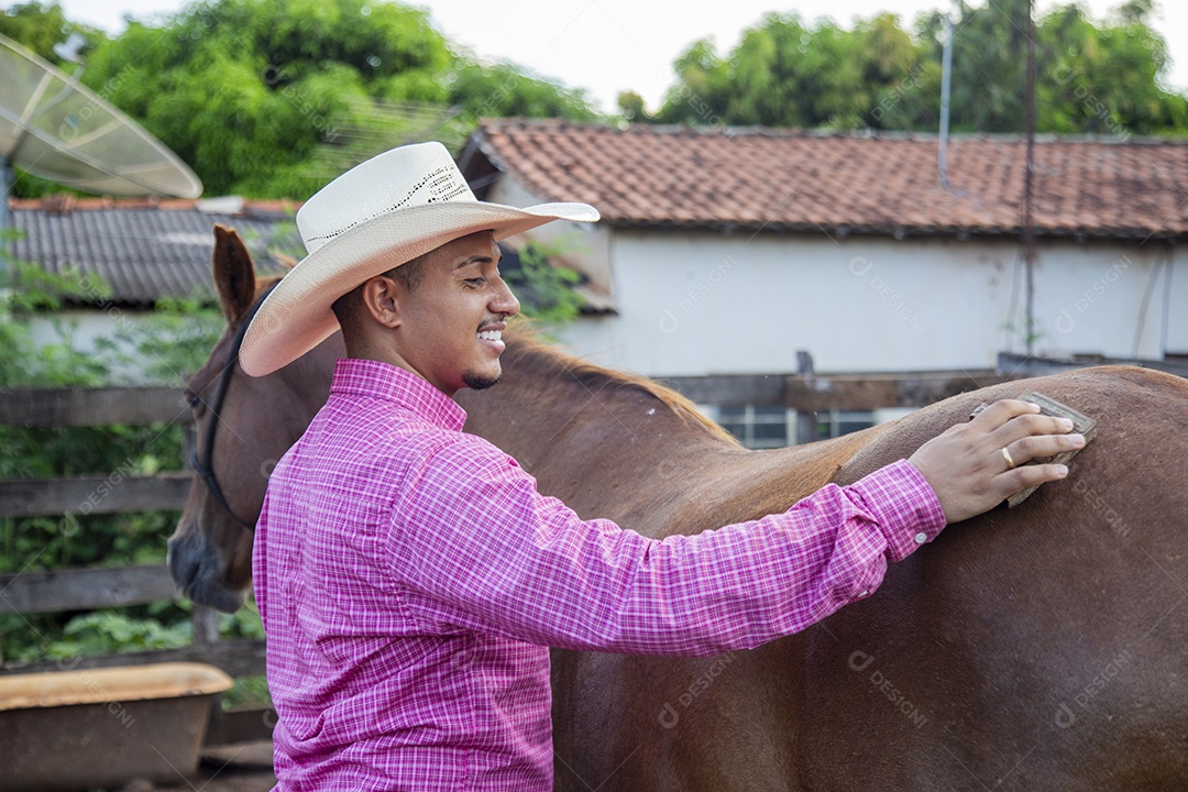 Homem jovem fazendeiro cuidando de seus cavalos