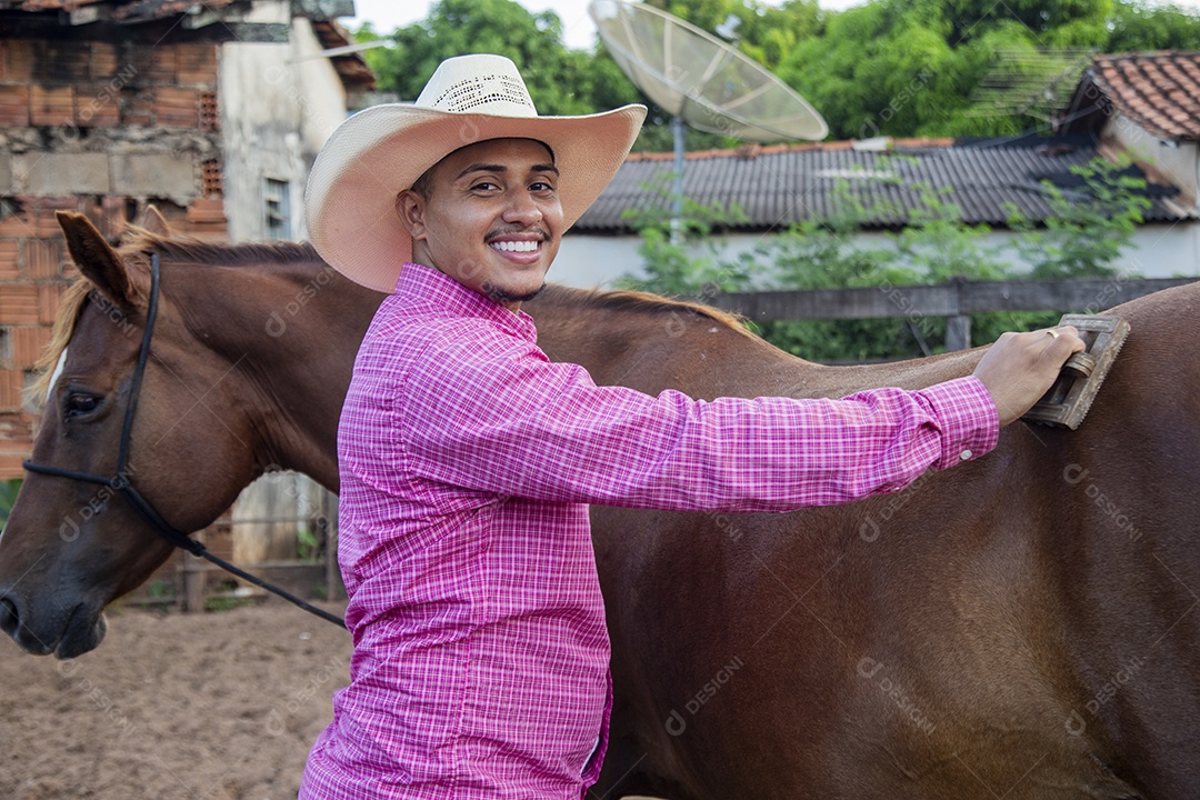 Homem jovem fazendeiro cuidando de seus cavalos