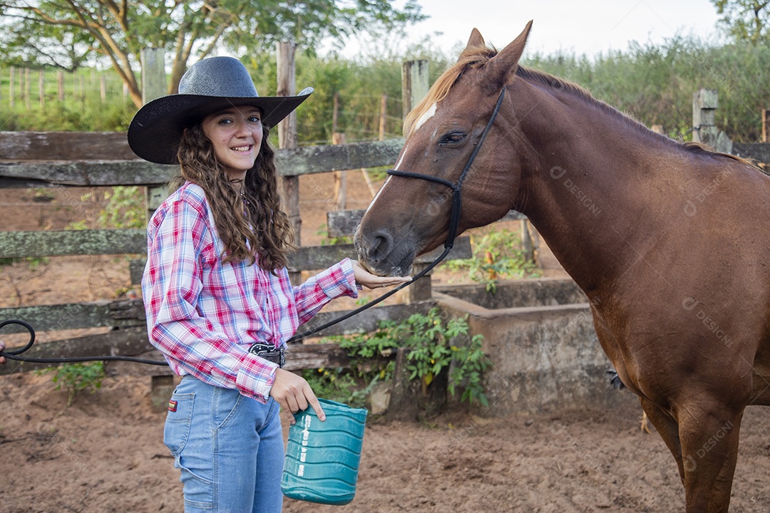 Menina jovem cuidando de seu cavalo