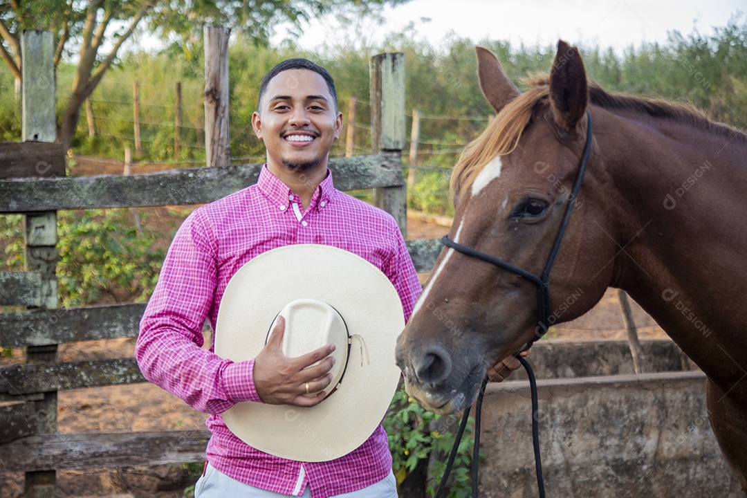 Homem jovem fazendeiro cuidando de seu cavalo