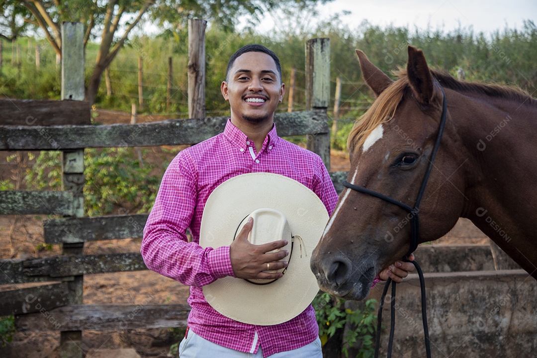 Homem jovem fazendeiro cuidando de seu cavalo