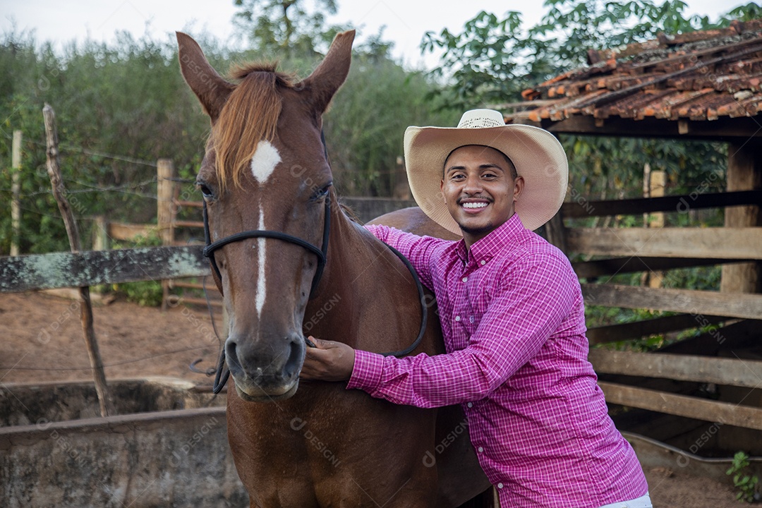 Homem jovem fazendeiro cuidando de seu cavalo