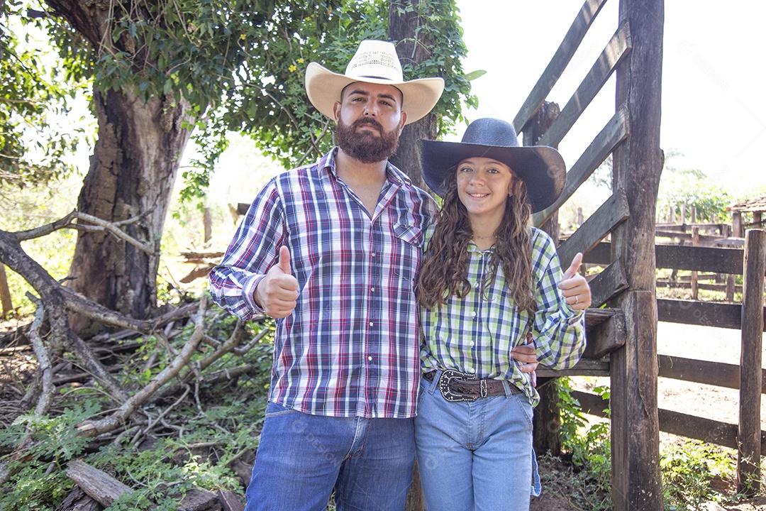 Pai fazendeiro ao lado de sua filha sobre fazenda