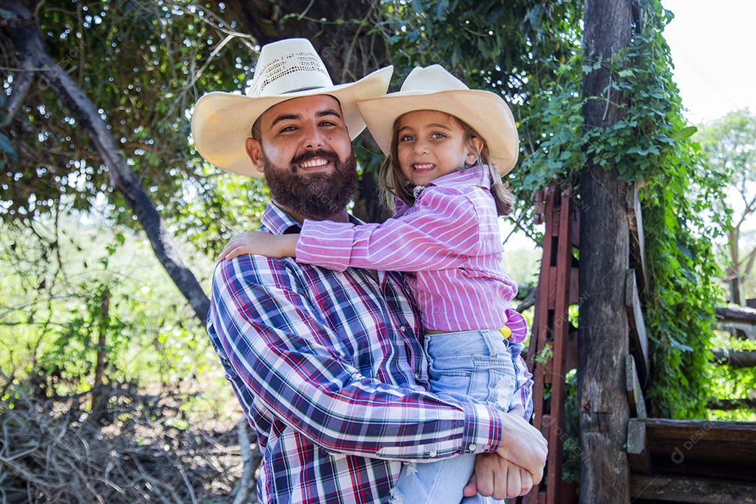 Pai fazendeiro ao lado de sua filha sobre fazenda
