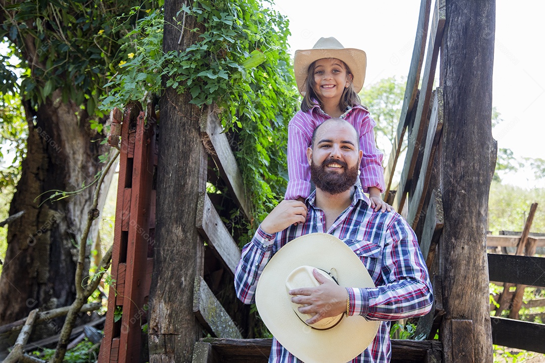 Pai fazendeiro ao lado de sua filha sobre fazenda