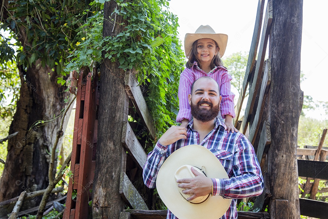 Pai fazendeiro ao lado de sua filha sobre fazenda
