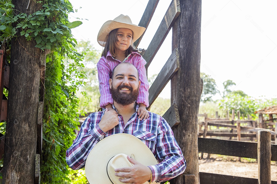 Pai fazendeiro ao lado de sua filha sobre fazenda