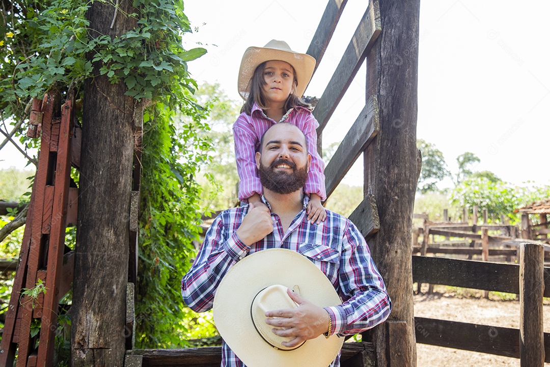 Pai fazendeiro ao lado de sua filha sobre fazenda