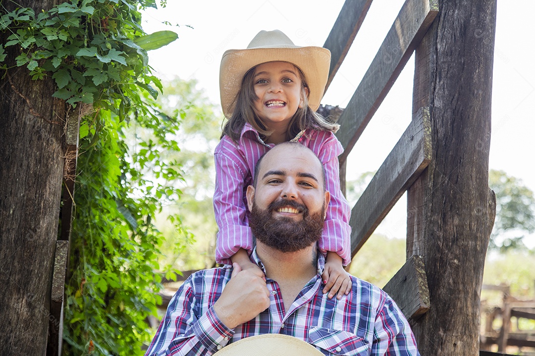 Pai fazendeiro ao lado de sua filha sobre fazenda