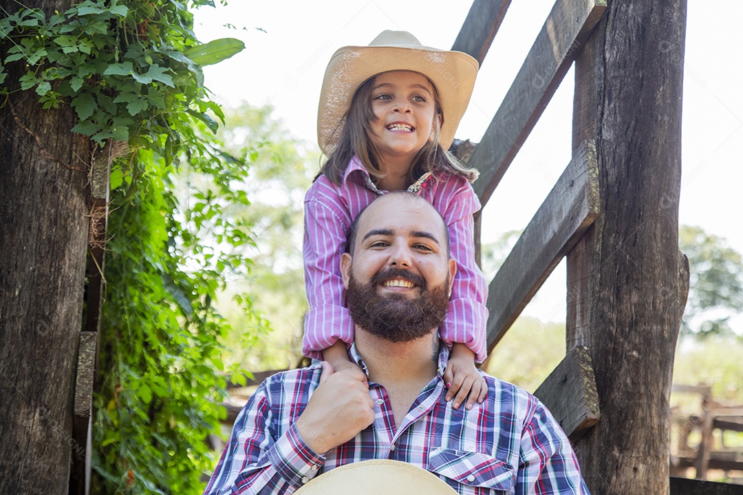 Pai fazendeiro ao lado de sua filha sobre fazenda