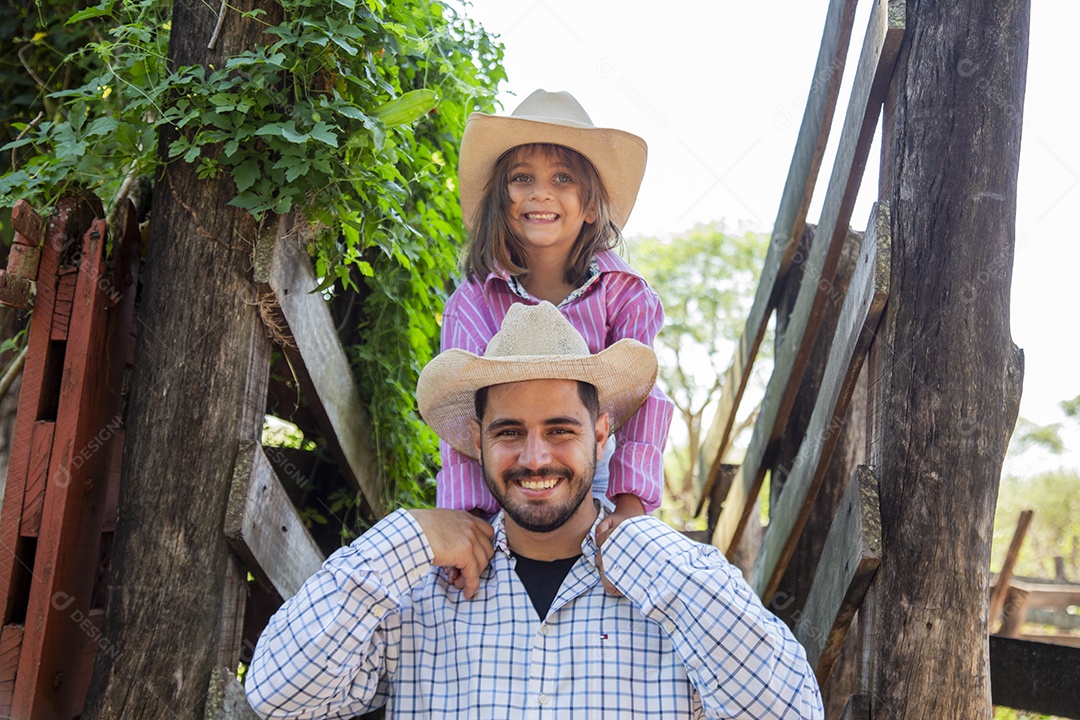 Pai fazendeiro ao lado de sua filha sobre fazenda