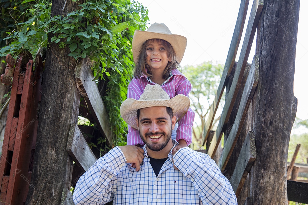 Pai fazendeiro ao lado de sua filha sobre fazenda