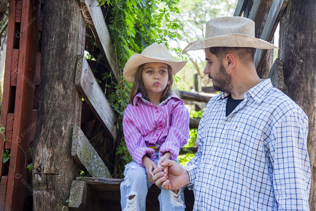 Pai fazendeiro ao lado de sua filha sobre fazenda