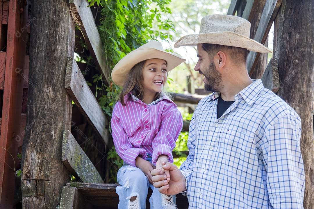 Pai fazendeiro ao lado de sua filha sobre fazenda