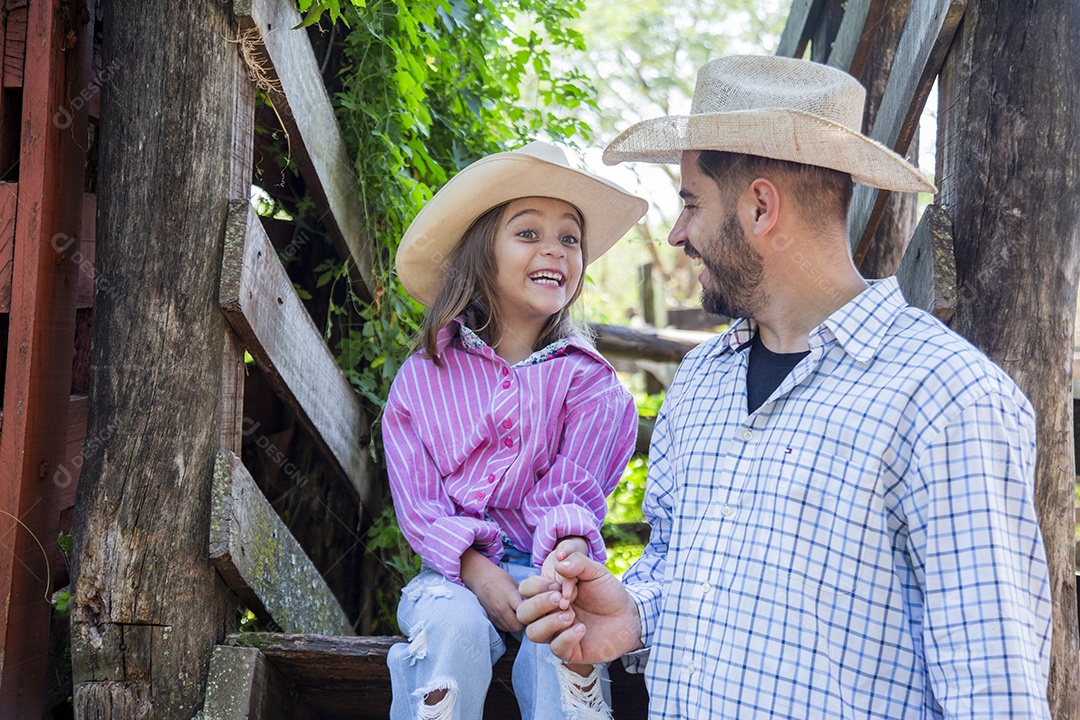 Pai fazendeiro ao lado de sua filha sobre fazenda