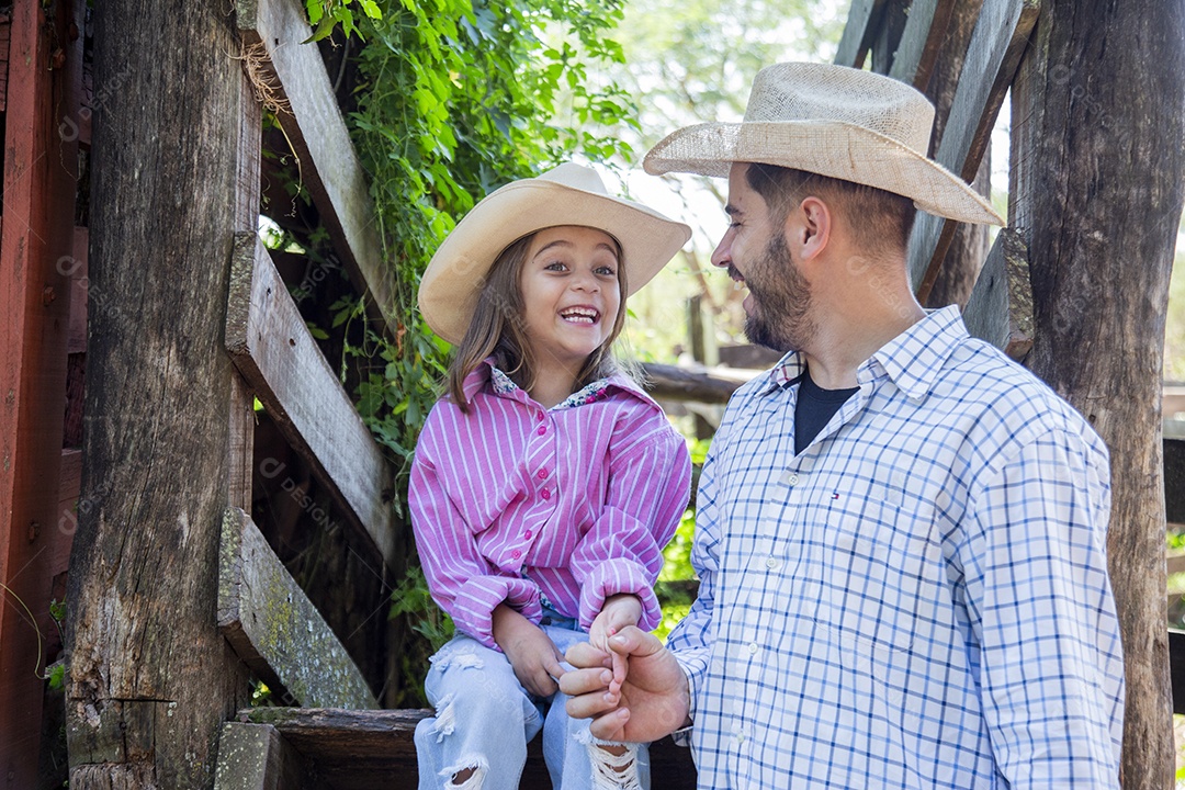 Pai fazendeiro ao lado de sua filha sobre fazenda