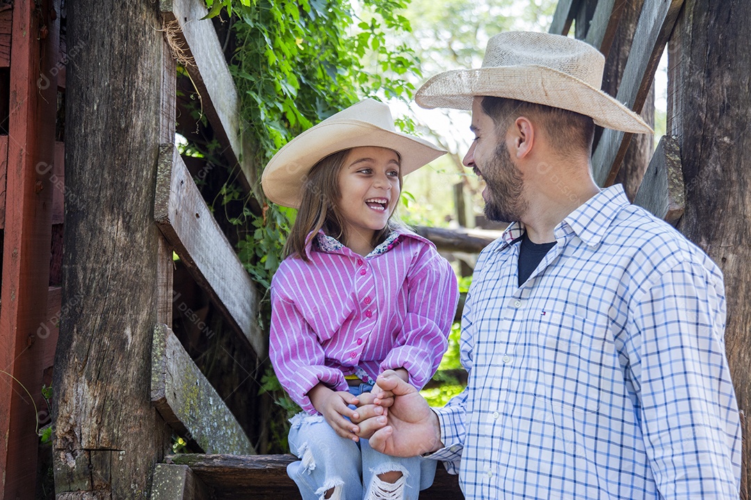 Pai fazendeiro ao lado de sua filha sobre fazenda