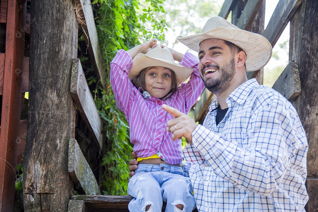 Pai fazendeiro ao lado de sua filha sobre fazenda