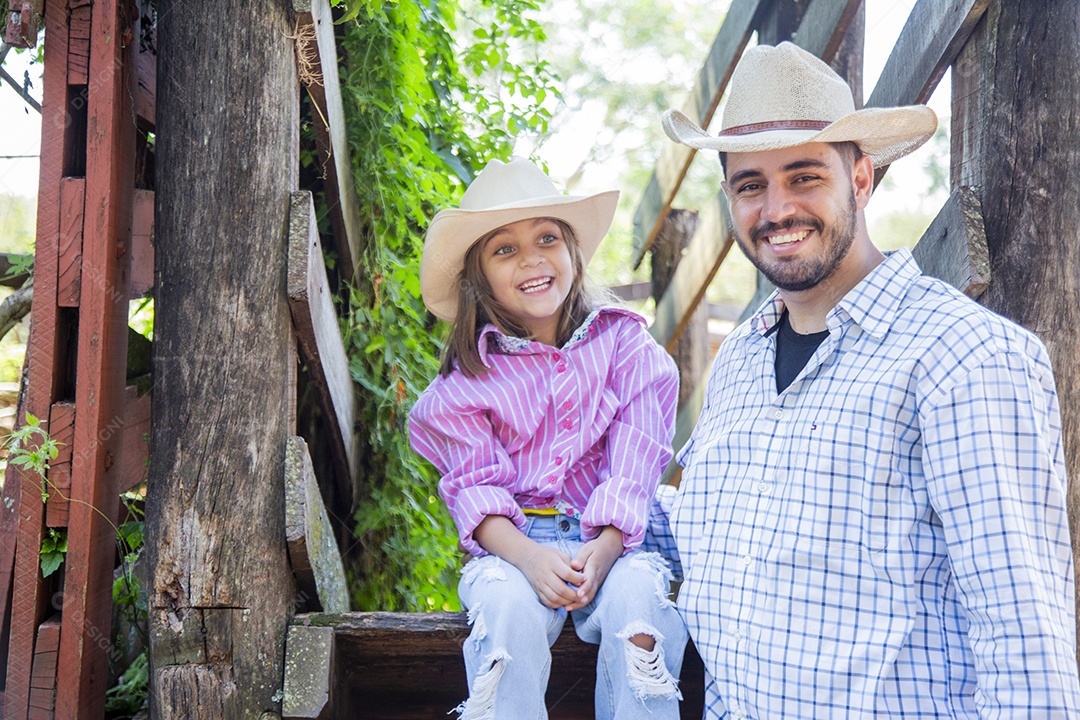 Pai fazendeiro ao lado de sua filha sobre fazenda