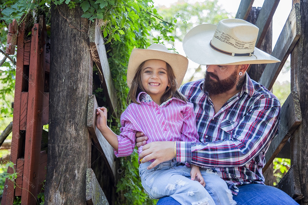Pai fazendeiro ao lado de sua filha sobre fazenda